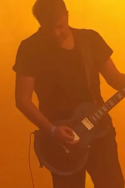 Frank steht im Nebel und hält eine Gitarre